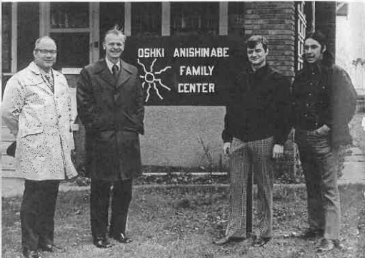 A group of people standing in front of a sign

Description automatically generated